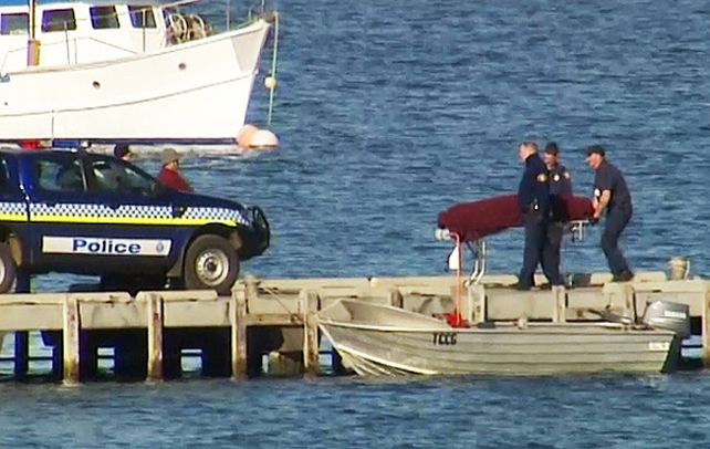 Penoso. La policía de la isla María traslada el cuerpo de la víctima.