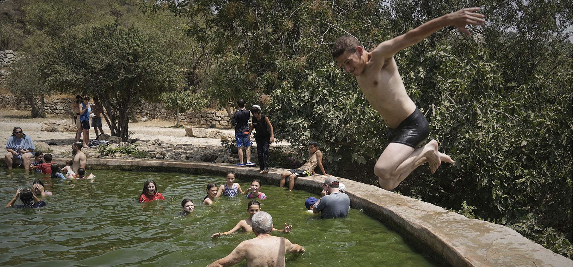Un hombre salta al agua mientras la gente se refresca en el manantial de Ein Lavan, en medio de una ola de calor, en las afueras de Jerusalén, el miércoles 13 de agosto de 2025. (Foto AP/Mahmoud Illean) Un hombre salta al agua mientras la gente se refresca en el manantial de Ein Lavan, en medio de una ola de calor, en las afueras de Jerusalén, el miércoles 13 de agosto de 2025. (Foto AP/Mahmoud Illean)