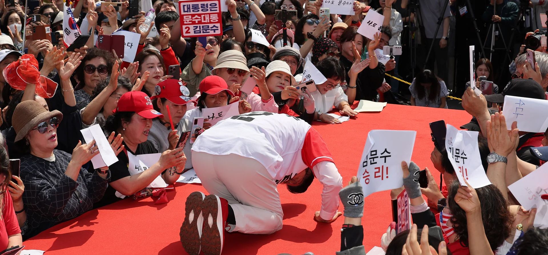 Kim Moon-soo (C), candidato presidencial del partido conservador Poder Popular, se inclina profundamente ante los votantes durante una parada de campaña en una terminal de autobuses exprés antes de las elecciones presidenciales del 3 de junio, Seúl, Corea del Sur. Fotografía: Yonhap/EPA Kim Moon-soo (C), candidato presidencial del partido conservador Poder Popular, se inclina profundamente ante los votantes durante una parada de campaña en una terminal de autobuses exprés antes de las elecciones presidenciales del 3 de junio, Seúl, Corea del Sur. Fotografía: Yonhap/EPA