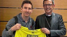 Messi junto a la camiseta de Athletica Vaticana y el monseñor Emmanuel Gobilliard.