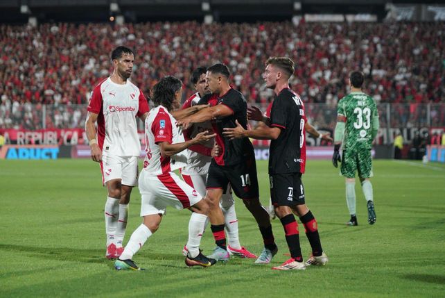 Jugadores de Newells forcejean con Malcorra luego de reprocharle sus reclamos al árbitro por los proyectiles.