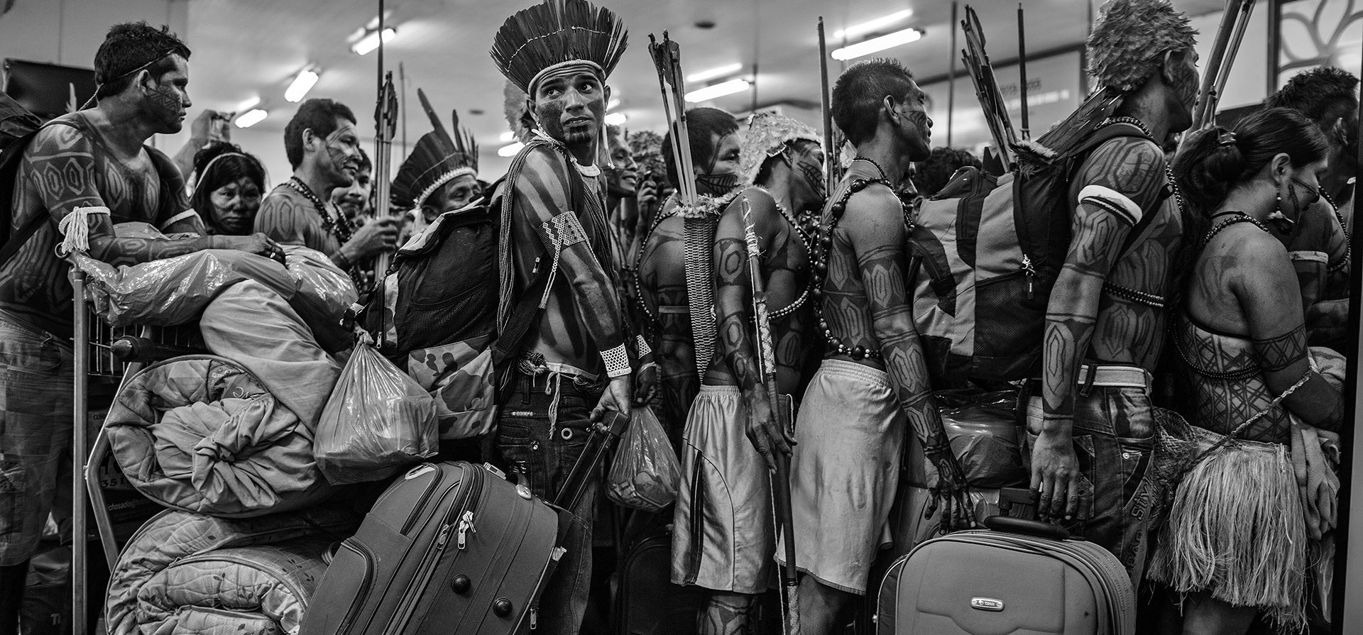 Image de una serie titulada Amazonian Dystopia, de Lalo de Almeida para Folha de Sao Paulo/Panos Pictures que ganó el premio World Press Photo Long-Term Project, muestra a miembros de la comunidad Mundurukú haciendo fila para abordan un avión en el aeropuerto de Altamira, en Pará, Brasil, el 14 de junio de 2013. Después de protestar en el lugar de construcción de la represa de Belo Monte en el río Xingu, viajaron a la capital del país, Brasilia, para presentar sus demandas al gobierno. (Lalo de Almeida para Folha de Sao Paulo/Panos