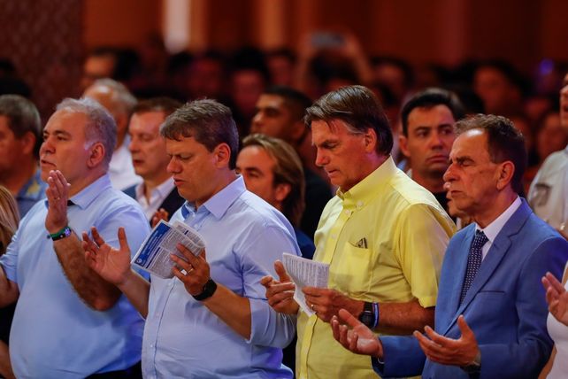 Bolsonaro (camisa amarilla) reza junto a su círculo más cercano en la Basílica de Aparecida
