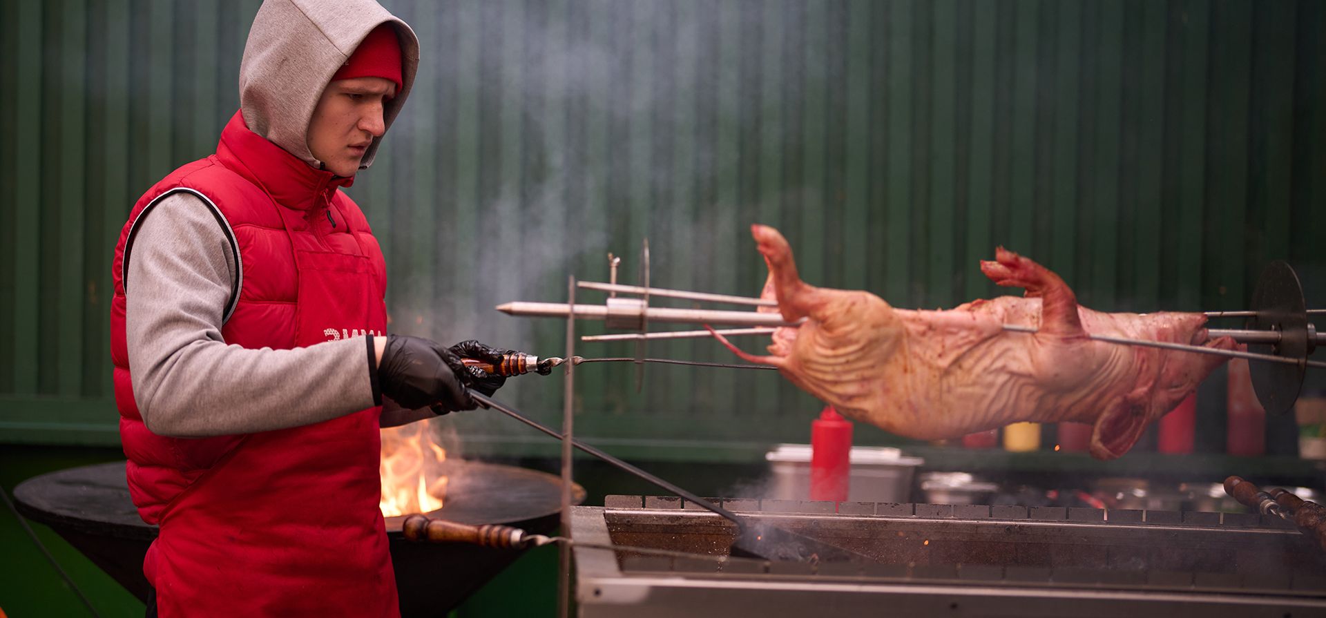 Un cocinero prepara un lechón en un asador sobre brasas en un café callejero durante la feria navideña inaugurada en la plaza Manezhnaya, cerca de la Plaza Roja de Moscú, el jueves 11 de diciembre de 2025. (Foto AP/Alexander Zemlianichenko)
