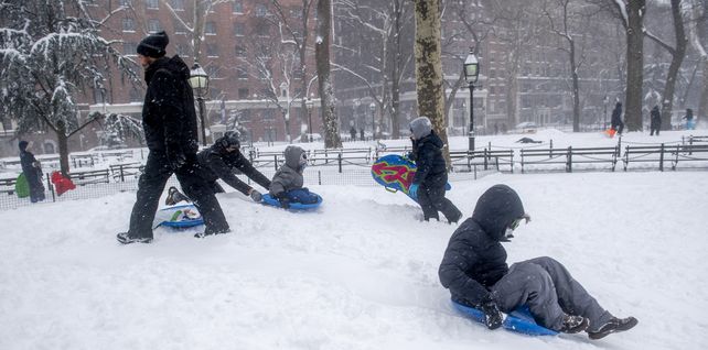 Familias juegan con sus hijos durante la tormenta de nieve en Washington Square Park en Nueva York. 