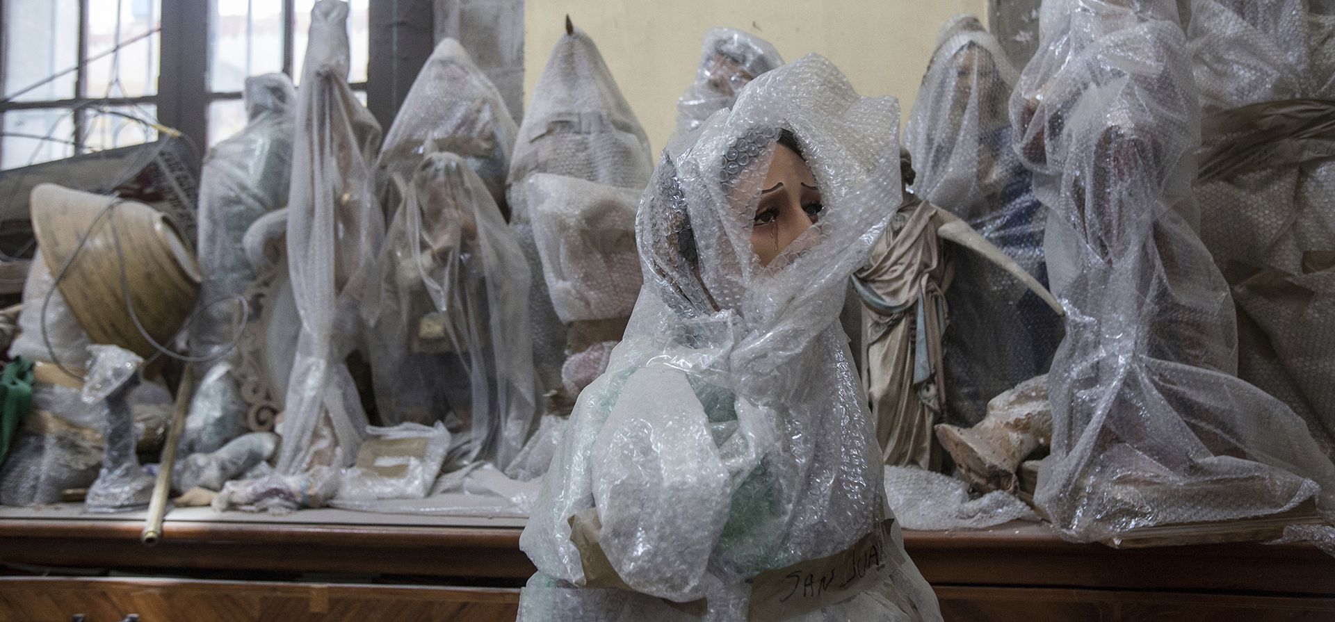 Vista de imágenes religiosas protegidas con plástico de burbujas perteneciente al Santuario Parroquial de Nuestra Señora de los Ángeles que fue dañado hace 5 años por un terremoto en la Ciudad de México, México. La Parroquia ha comenzado los trabajos de restauración, que perdió la mitad de su cúpula y conserva la imagen de una virgen que se considera milagrosa porque ha sobrevivido a inundaciones y terremotos.