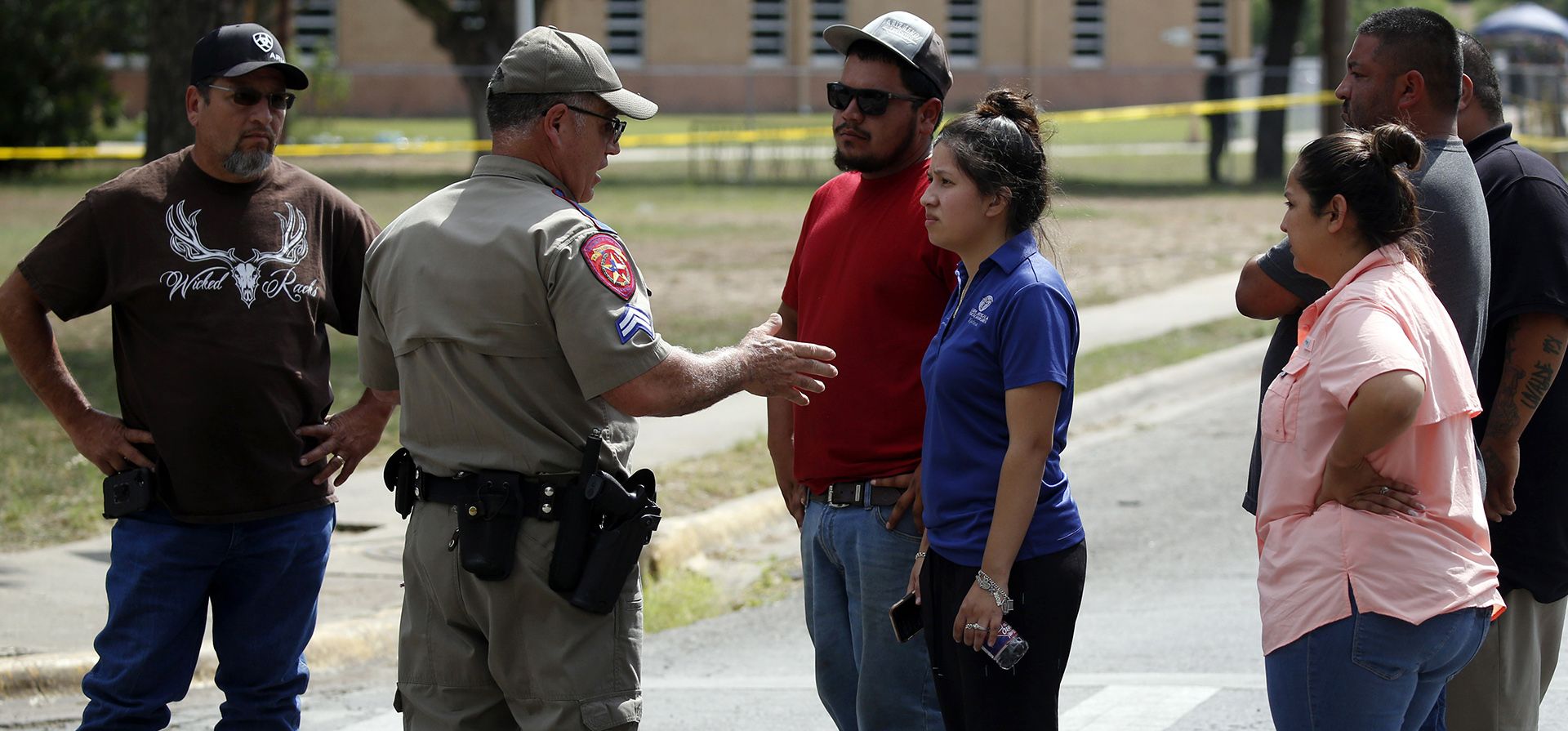 Un policía habla con personas que piden información fuera de la Escuela Primaria Robb en Uvalde, Texas, el martes 24 de mayo de 2022. Un hombre armado de 18 años abrió fuego en la escuela primaria de Texas y mató a varias personas.