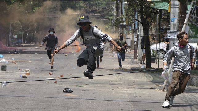 Manifestantes antigolpistas corren para evitar las fuerzas militares durante una manifestación en Yangon