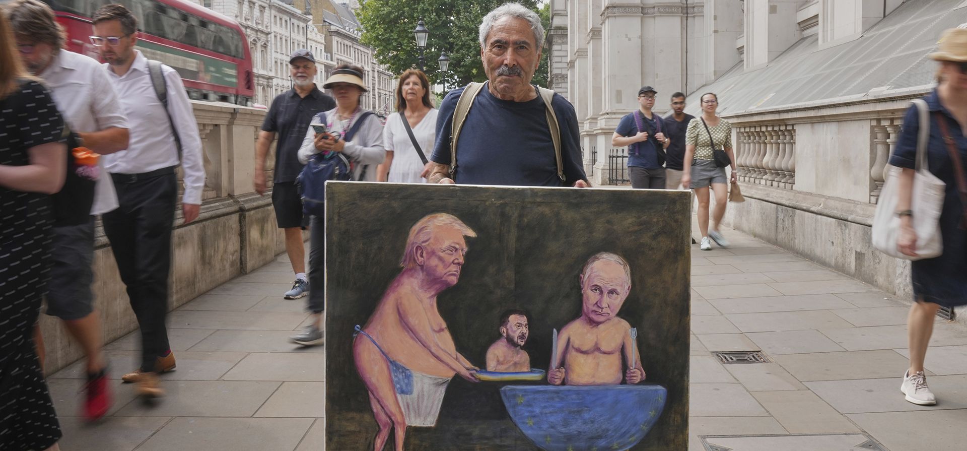 El artista satírico Kaya Mar exhibe su última pintura, que representa al presidente Trump, al presidente ruso Putin y al presidente ucraniano Zelenskyy, frente a Downing Street, en Londres, el miércoles 13 de agosto de 2025. (Foto AP/Joanna Chan) El artista satírico Kaya Mar exhibe su última pintura, que representa al presidente Trump, al presidente ruso Putin y al presidente ucraniano Zelenskyy, frente a Downing Street, en Londres, el miércoles 13 de agosto de 2025. (Foto AP/Joanna Chan)