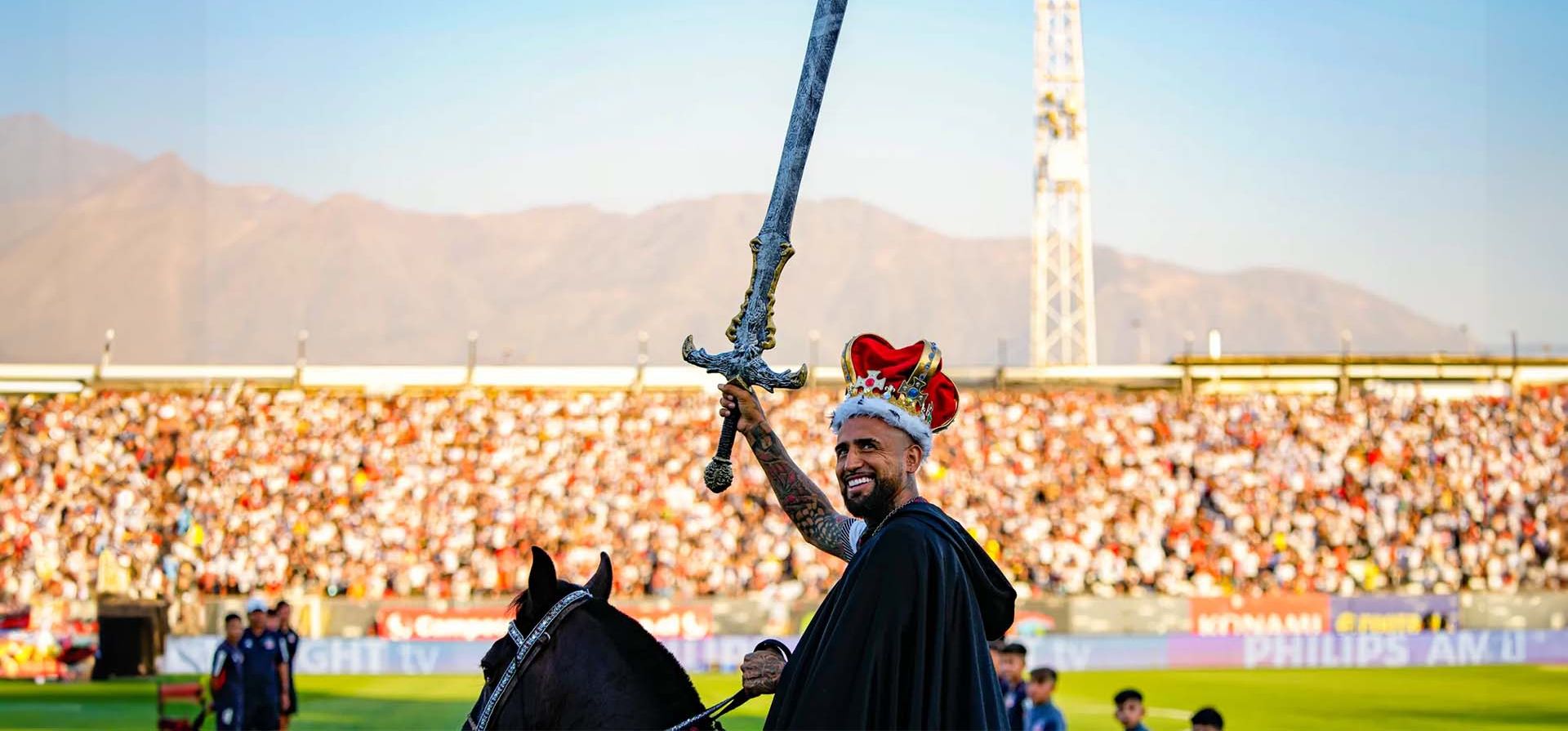 Arturo Vidal agita una espada mientras monta a caballo en el césped de su acto de bienvenida en el Colo Colo del Estadio Monumental, Santiago, Chile. Fotografía: Esteban Félix/AP Arturo Vidal agita una espada mientras monta a caballo en el césped de su acto de bienvenida en el Colo Colo del Estadio Monumental, Santiago, Chile. Fotografía: Esteban Félix/AP