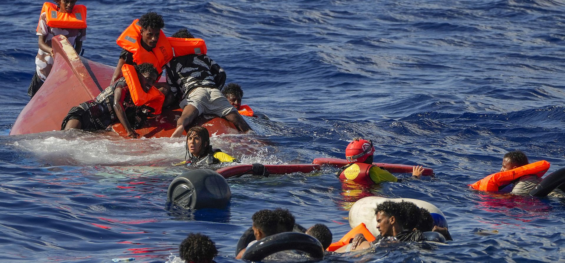 Socorristas de la ONG española Open Arms ayudan a los migrantes después de que su bote de madera volcara durante una operación de rescate en el sur de la isla italiana de Lampedusa en el mar Mediterráneo, el jueves 11 de agosto de 2022.