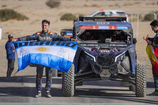 El rosarino Osman Anuar muestra orgulloso la bandera de su ciudad en el Dakar de Arabia Saudita.