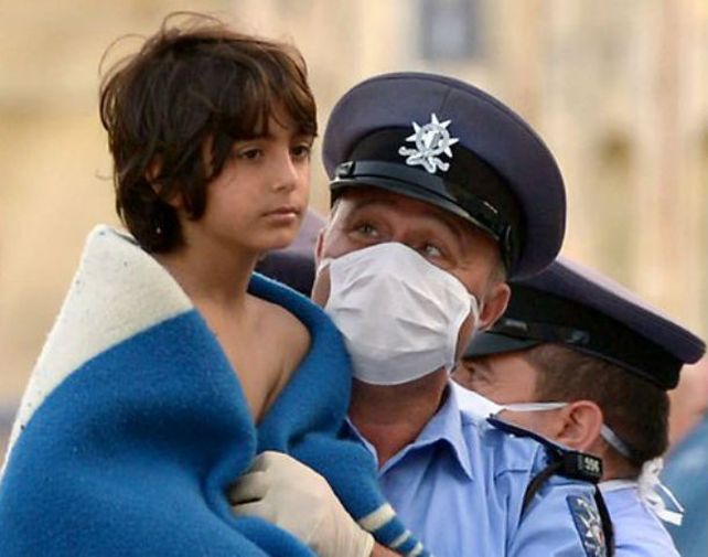 Miradas. Un chico rescatado de una de las barcazas que naufragó no sabe qué le espera. Al guardia lo reconforta haberlo salvado.