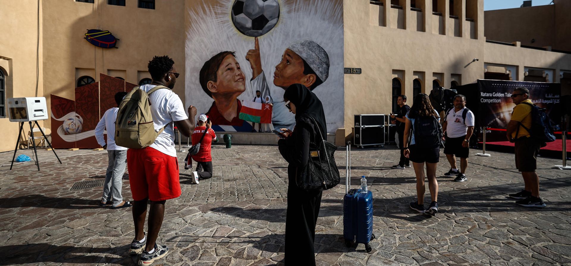 Varias personas toman fotos de un mural en Katara Doha, Qatar, donde se celebra el Mundial de fútbol. EFE/Juan Ignacio Roncoroni  