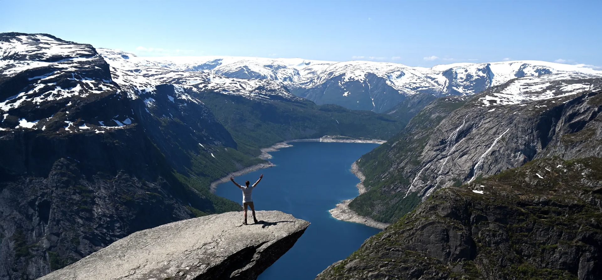 Un hombre posa para una foto en la formación rocosa Trolltunga ( Un hombre posa para una foto en la formación rocosa Trolltunga (