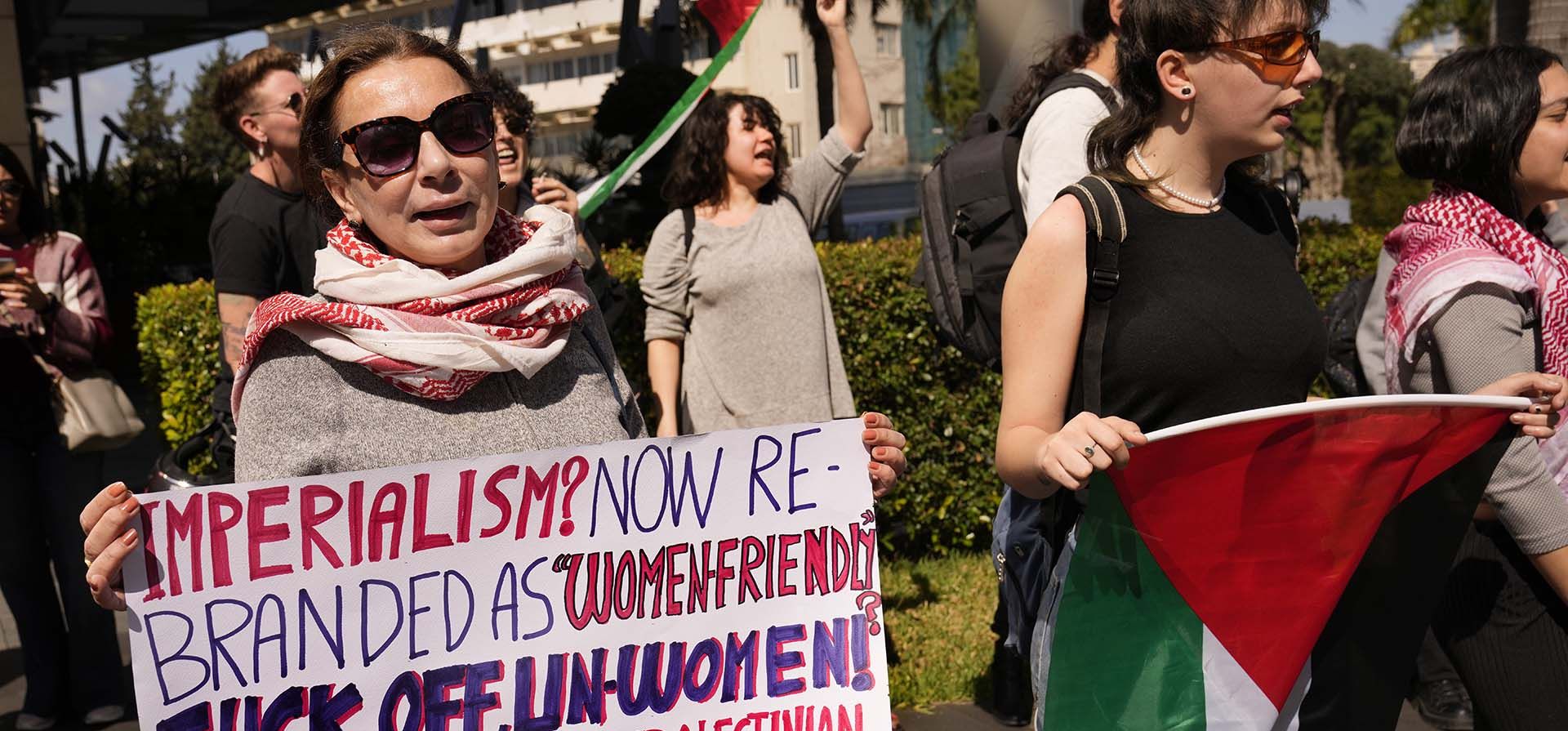 Una mujer libanesa sostiene una pancarta mientras grita consignas durante una protesta para apoyar a las mujeres palestinas en el Día Internacional de la Mujer frente a la oficina de una organización de la ONU, en Beirut, Líbano, el viernes 8 de marzo de 2024. La agencia de la ONU para Palestina refugiados dice que unas 9.000 mujeres han sido asesinadas en la Franja de Gaza desde que comenzó la guerra entre Israel y Hamas hace cinco meses. (Foto AP/Hussein Malla) Una mujer libanesa sostiene una pancarta mientras grita consignas durante una protesta para apoyar a las mujeres palestinas en el Día Internacional de la Mujer frente a la oficina de una organización de la ONU, en Beirut, Líbano, el viernes 8 de marzo de 2024. La agencia de la ONU para Palestina refugiados dice que unas 9.000 mujeres han sido asesinadas en la Franja de Gaza desde que comenzó la guerra entre Israel y Hamas hace cinco meses. (Foto AP/Hussein Malla)