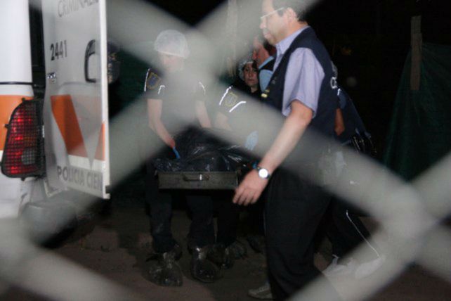 A la morgue. Los agentes de Criminalística retiran el cadáver de la vivienda ubicada en El Algarrobal.