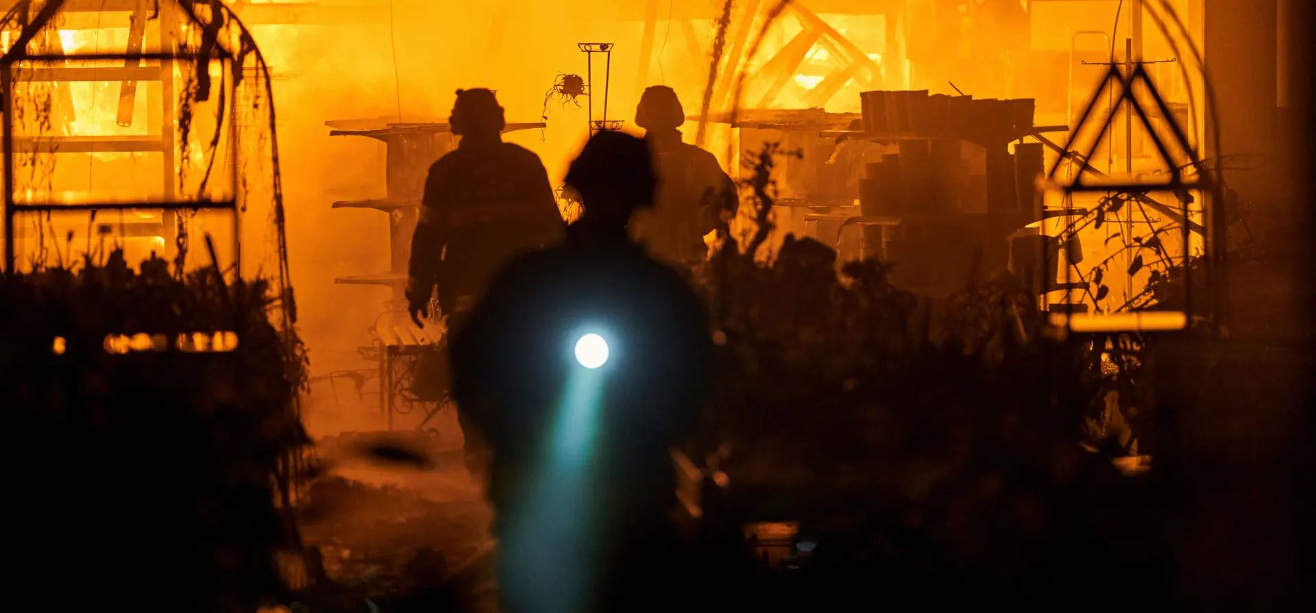 Los bomberos entran en un centro comercial que fue destruido por los bombardeos rusos, Kherson, Ucrania. Fotografía: LIBKOS/AP