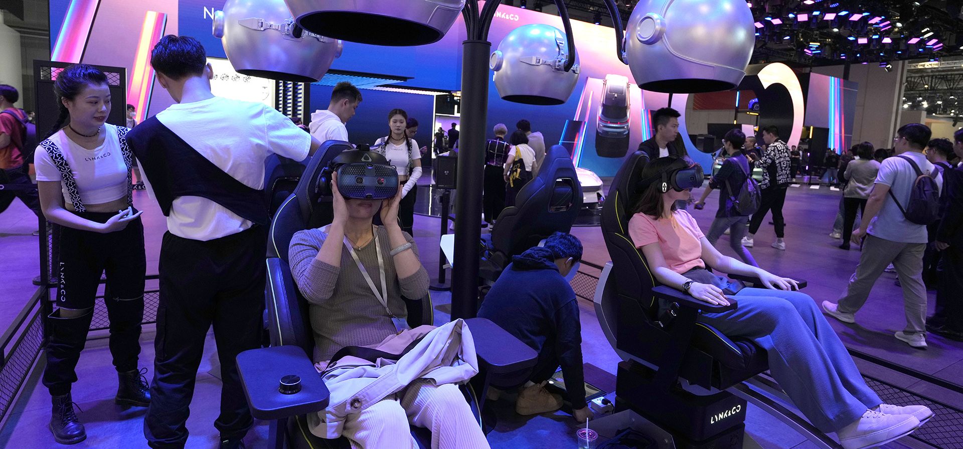 Los asistentes participan en experiencias de realidad virtual en la feria Auto Shanghai 2023 en Shanghái, el martes 18 de abril de 2023. Los fabricantes de automóviles globales y chinos planean presentar más de una docena de nuevos SUV, sedanes y muscle cars eléctricos esta semana. (Foto AP/Ng Han Guan)