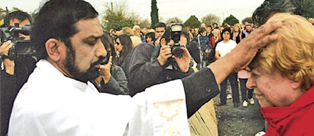 Ignacio Peries impone las manos a una mujer en San Martín.