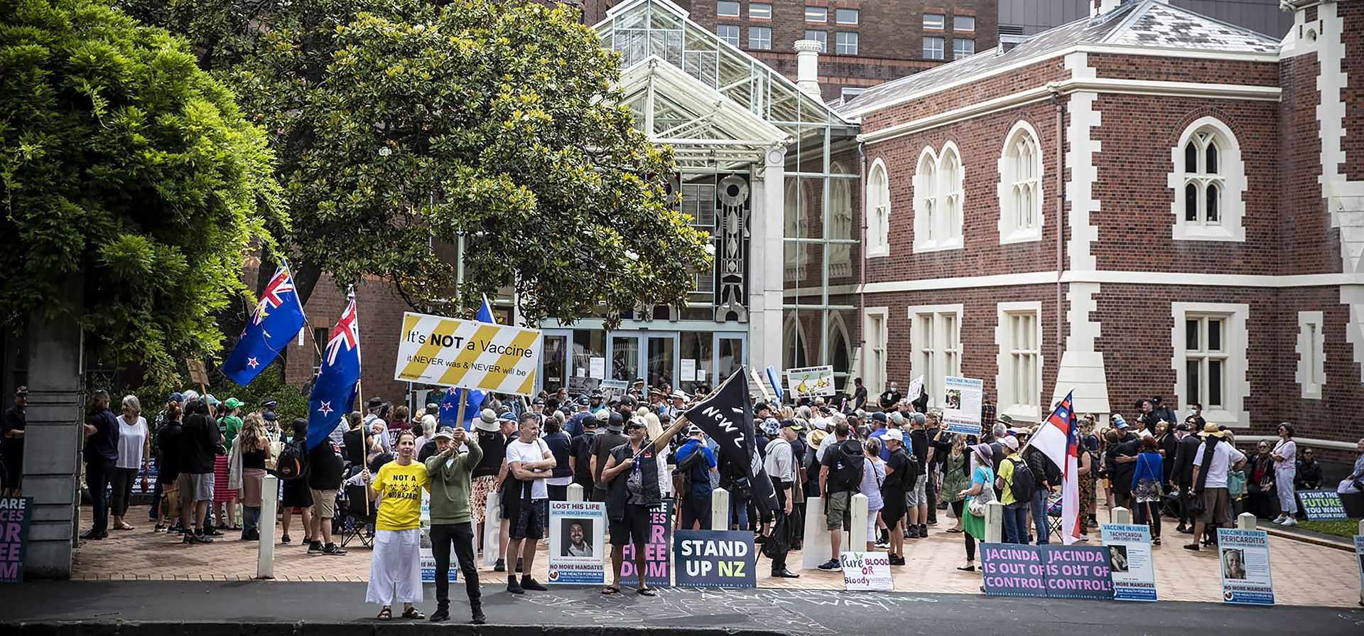 Manifestantes antivacunas apoyan a los padres de un bebé de cuatro meses que necesita una operación cardíaca urgente, se manifiestan frente al Tribunal Superior en Auckland, Nueva Zelanda, el martes 6 de diciembre de 2022. El tribunal el miércoles 7 de diciembre de 2022, falló en contra de la familia que había rechazado transfusiones de sangre para su bebé a menos que la sangre proviniera de donantes que no habían sido vacunados contra el COVID-19. (Michael Craig/New Zealand Herald vía AP)