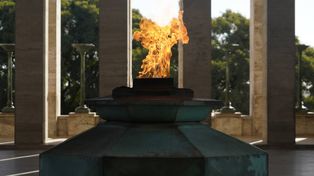 La llama votiva ilumina el centro del Propileo