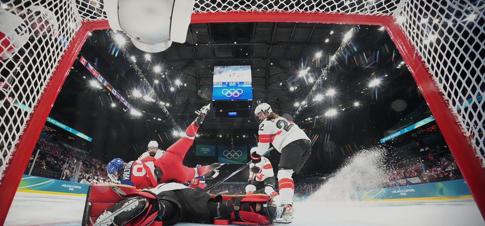 La checa Kristyna Kaltounkova (izquierda) cae sobre la suiza Saskia Maurer al anotar el primer gol de su equipo durante un partido de la ronda preliminar de hockey sobre hielo femenino entre Suiza y la República Checa en los Juegos Olímpicos de Invierno de 2026, en Milán, Italia, el viernes 6 de febrero de 2026. (David W. Cherny/Pool Photo vía AP)