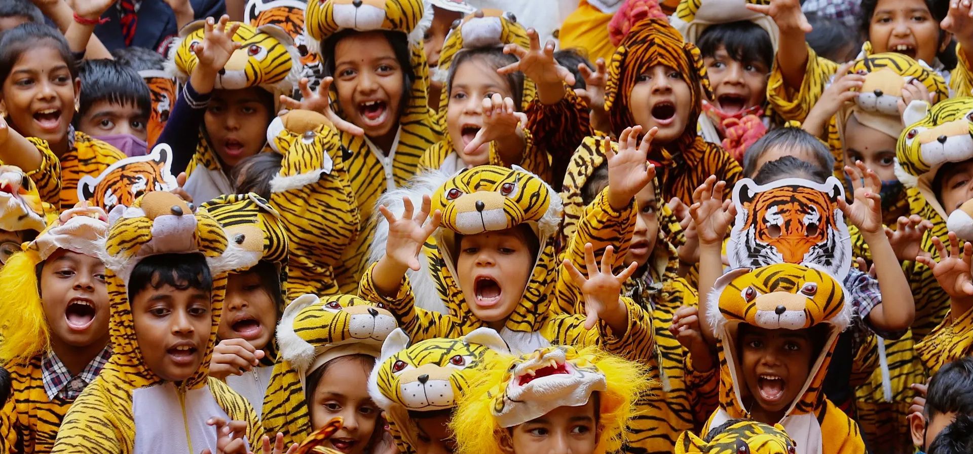 Niños escolares indios con disfraces y máscaras de tigre participan en la campaña de concientización Save Our Tiger en el Día Internacional del Tigre en Bangalore, India.
