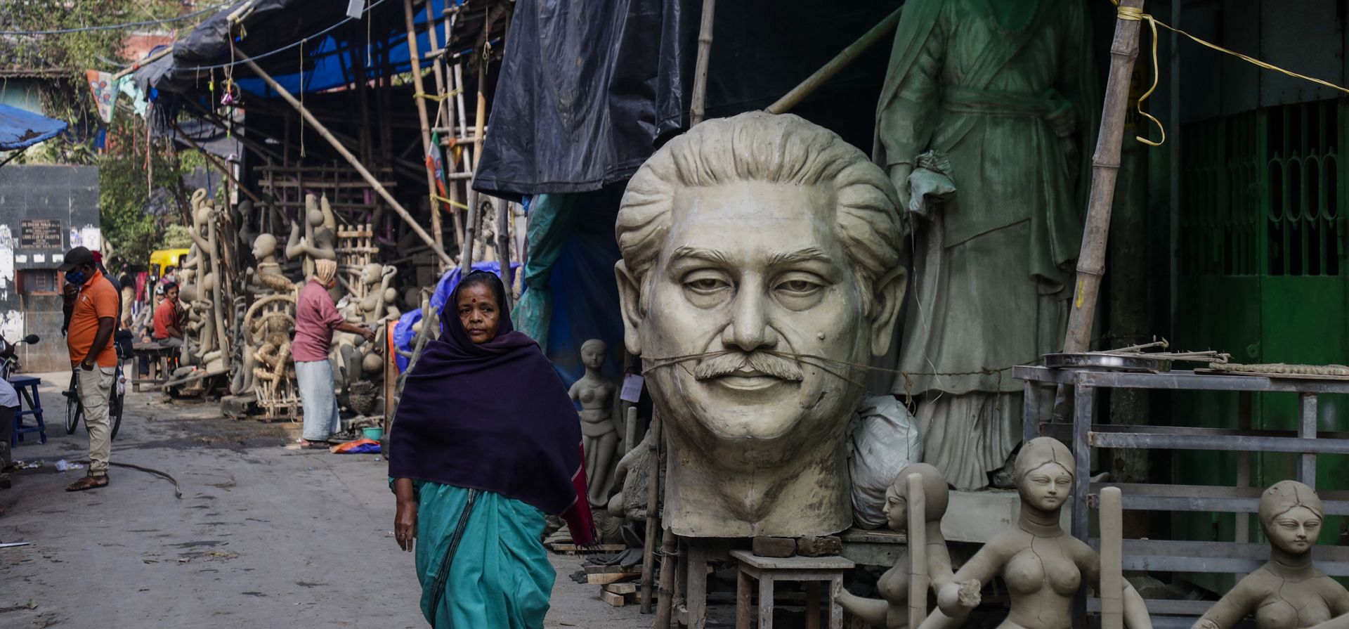 Una mujer pasa junto a un busto del jeque Mujibur Rahman, padre fundador de Bangladesh, en Kumortuli, la casa del alfarero en Calcuta, India, el lunes 17 de enero de 2022.