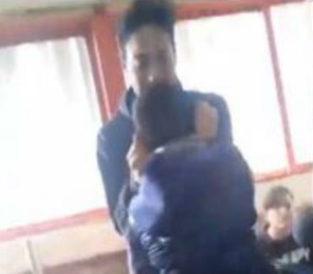 Un video muestra como a un chico lo levanta de las orejas un alumno