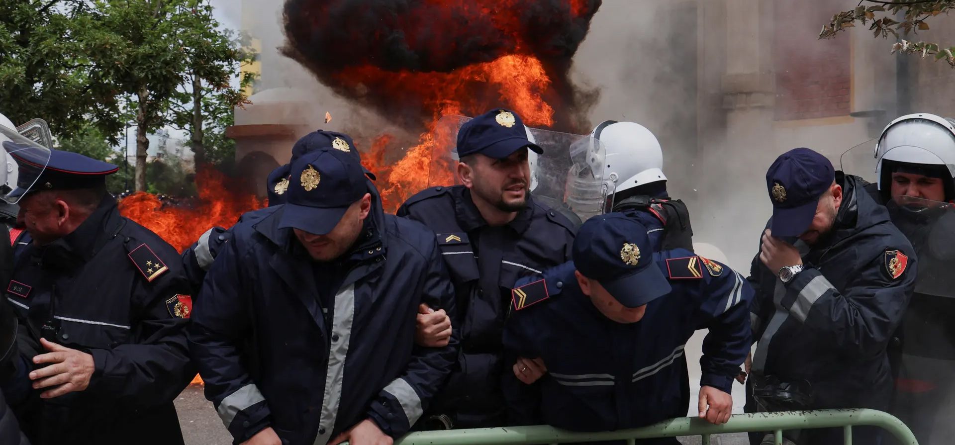 Agentes de policía reaccionan mientras simpatizantes de la oposición lanzan cócteles molotov contra la oficina del alcalde acusándolo de corrupción, Tirana, Albania. Fotografía: Florion Goga/Reuters Agentes de policía reaccionan mientras simpatizantes de la oposición lanzan cócteles molotov contra la oficina del alcalde acusándolo de corrupción, Tirana, Albania. Fotografía: Florion Goga/Reuters