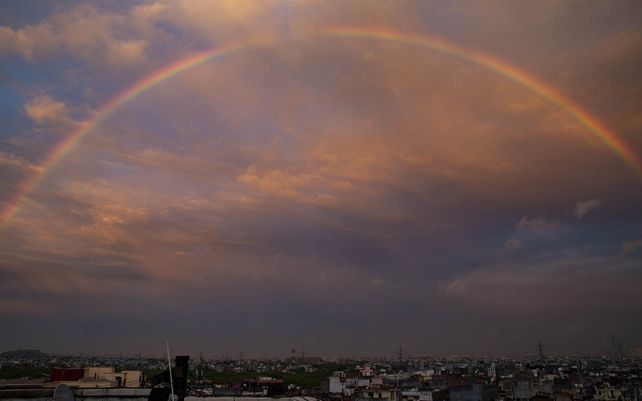 Un arco iris aparece en el horizonte después de una breve lluvia en Nueva Delhi, India, el lunes 18 de octubre de 2021.