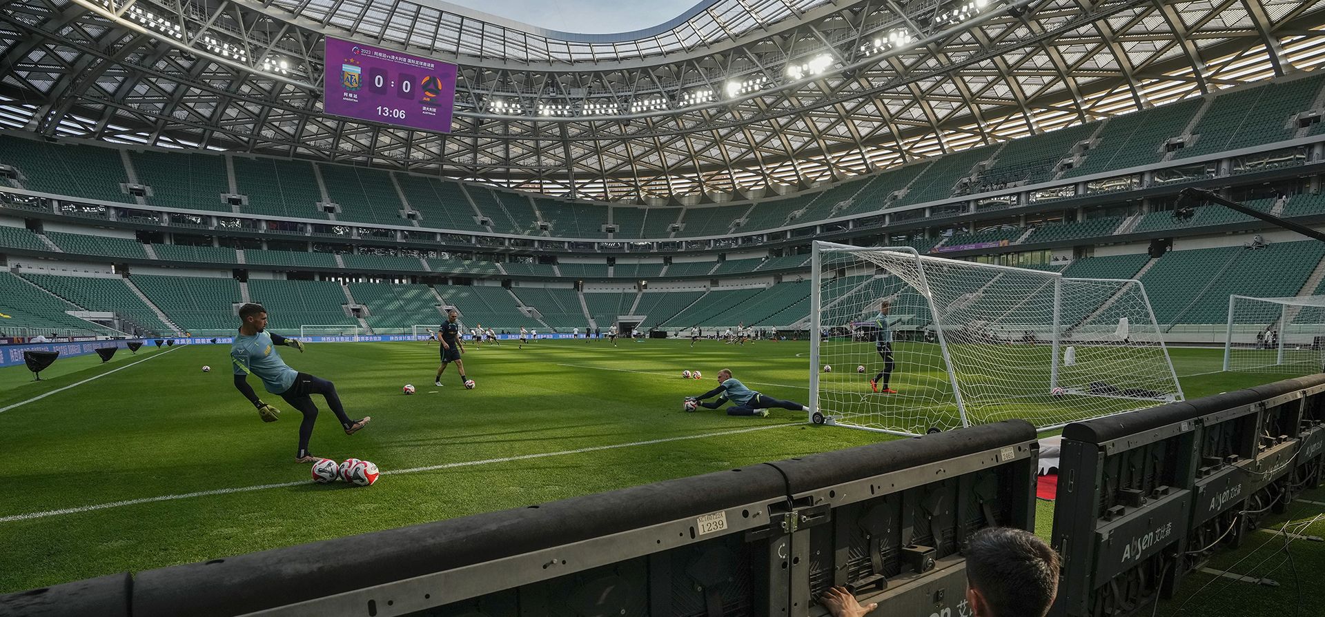 Un trabajador arregla los tableros publicitarios mientras los jugadores de la selección de fútbol de Australia asisten a una sesión de práctica en el renovado Estadio de los Trabajadores un día antes de su partido amistoso de fútbol contra Argentina, campeón de la Copa del Mundo 2022, en Beijing. (Foto AP/ Andy Wong) Un trabajador arregla los tableros publicitarios mientras los jugadores de la selección de fútbol de Australia asisten a una sesión de práctica en el renovado Estadio de los Trabajadores un día antes de su partido amistoso de fútbol contra Argentina, campeón de la Copa del Mundo 2022, en Beijing. (Foto AP/ Andy Wong)
