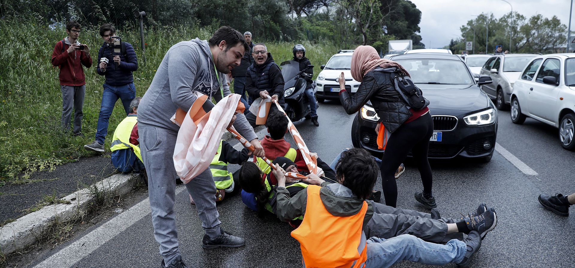 La gente retira a los manifestantes de Última Generación de un bloque en la carretera Appia Nuova en Roma, el lunes 24 de abril de 2023, durante el último de los cuatro días denominados por Extinction Rebellion como la protesta "La Grande", cuatro días planificados de acción internacional. (Cecilia Fabiano/LaPresse vía AP)