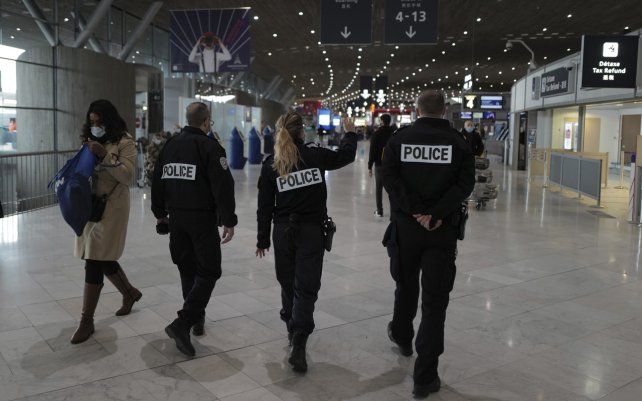 Agentes de la policía francesa patrullan en la sala de embarque del aeropuerto Charles de Gaulle de París en Roissy. Francia está cerrando sus fronteras a las personas que llegan de fuera de la Unión Europea.