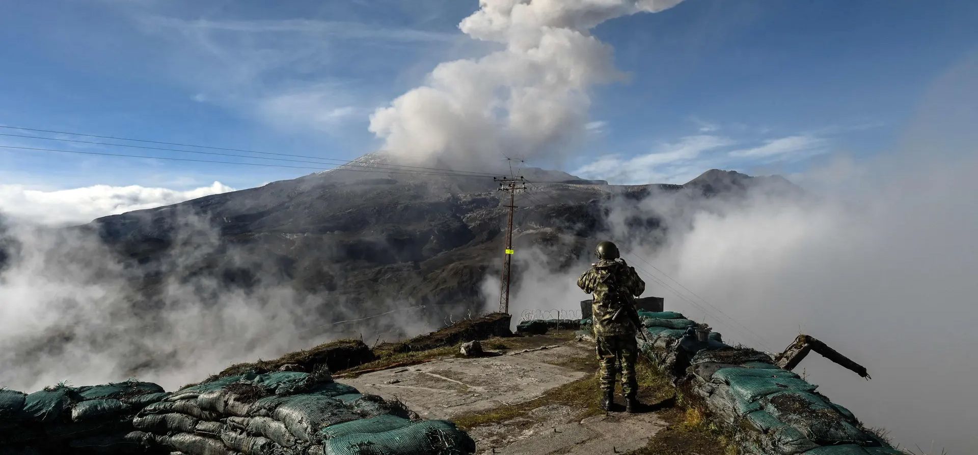 Caldas, Colombia. Un soldado observa el volcán Nevado del Ruiz mientras emite una nube de ceniza. Las autoridades han recomendado la evacuación de las ciudades cercanas debido a la actividad sísmica que podría desencadenar una erupción. Fotografía: Joaquín Sarmiento/AFP/Getty Images