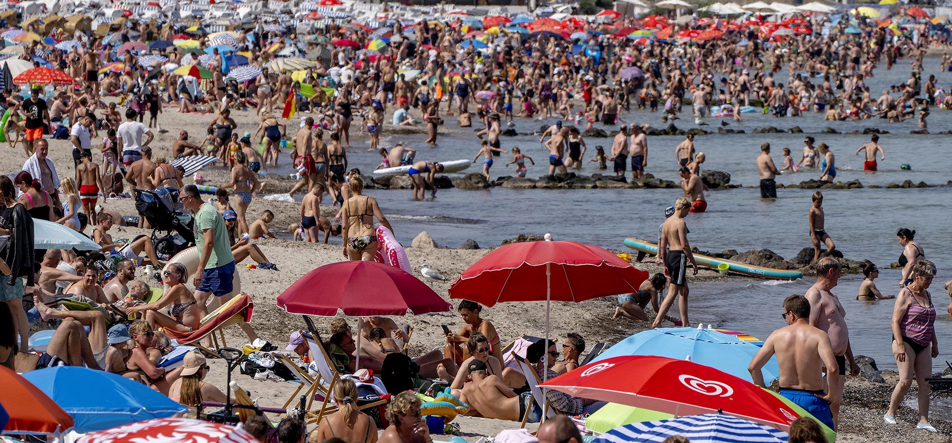 Turistas pasan un día en una playa llena de gente en el Mar Báltico en Timmendorfer Strand, Alemania, el miércoles 3 de agosto de 2022.