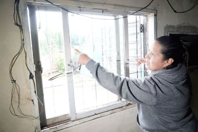 Brenda muestra los impactos en la ventana de la casa de su padre. La vivienda fue atacada dos veces en una semana.