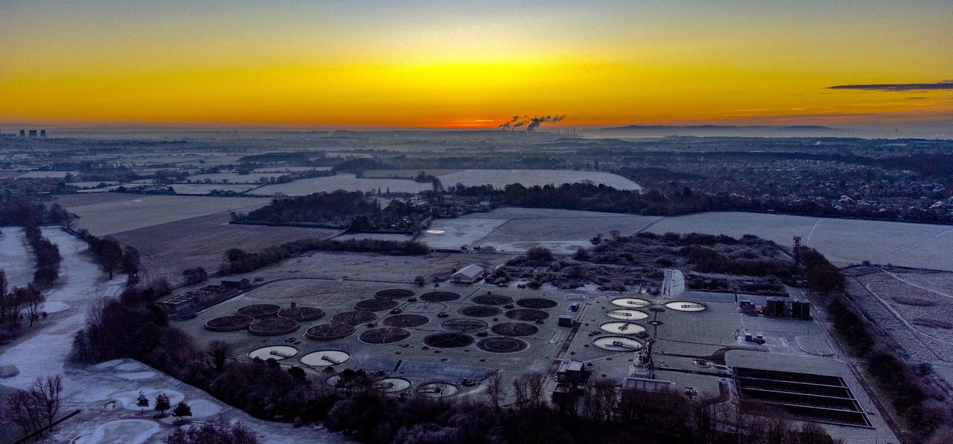El sol sale sobre una planta de tratamiento de agua en Liverpool, Inglaterra, el miércoles 14 de diciembre de 2022. La nieve y el hielo han barrido partes del Reino Unido, con condiciones invernales frías que continuarán durante días. (Peter Byrne/PA vía AP)