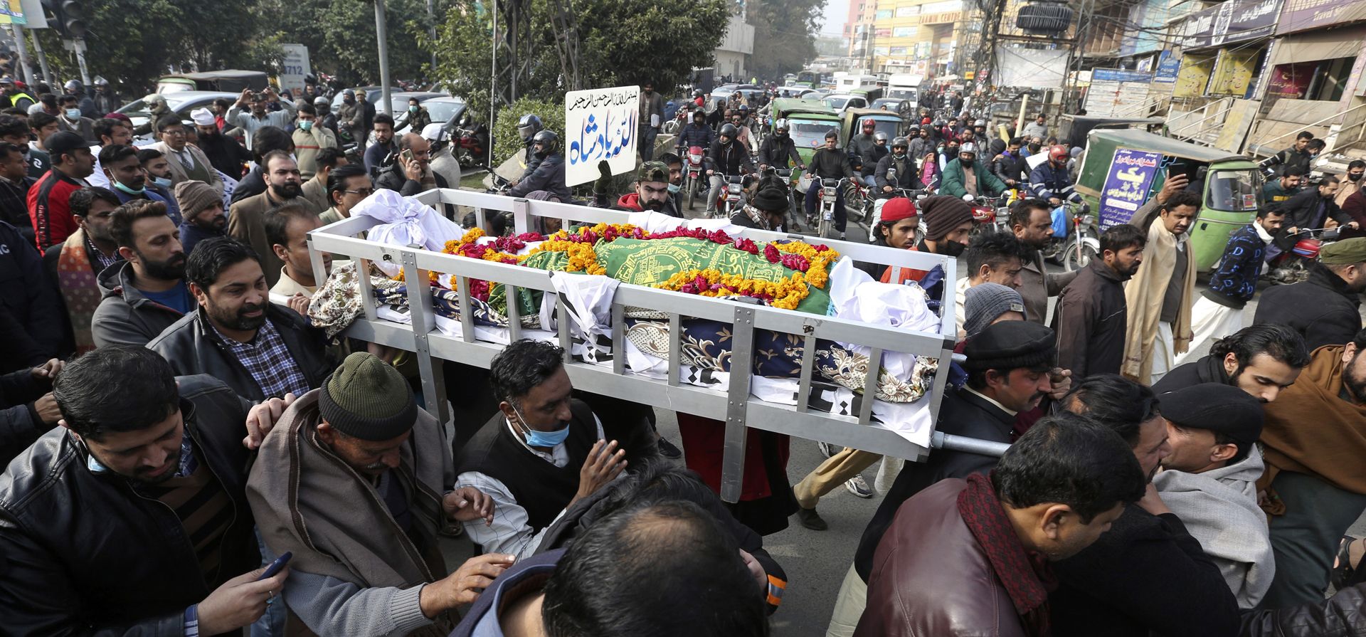 Personas cargan el cuerpo del periodista pakistaní Husnain Shah, quien fue asesinado por hombres armados, en Lahore, Pakistán, el martes 25 de enero de 2022. Hombres armados en una motocicleta dispararon y mataron a Shah, que trabajaba para Capital TV, canal de noticias como reportero.