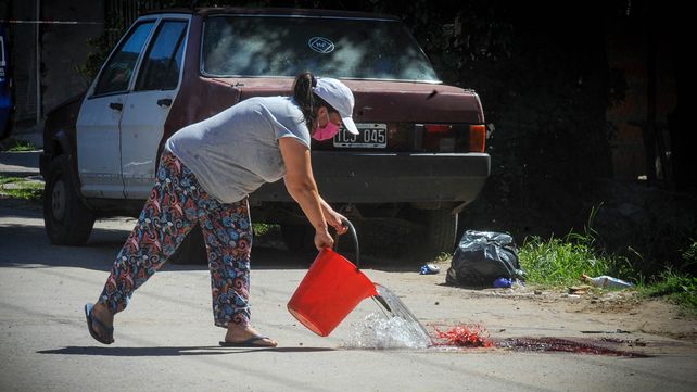 Una vecina limpia la calle luego del doble homicidio en Lavalle y Amenábar.