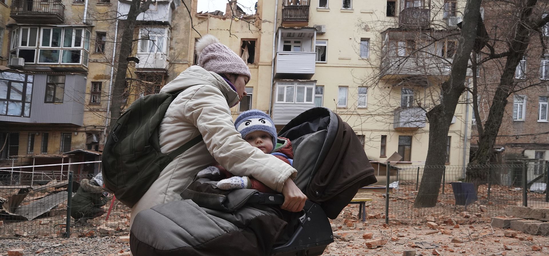 Una mujer carga a su hijo mientras evacuan un edificio residencial que fue alcanzado por un cohete ruso en el centro de la ciudad de Kharkiv, Ucrania, el lunes 30 de enero de 2023. (Foto AP/Andrii Marienko)