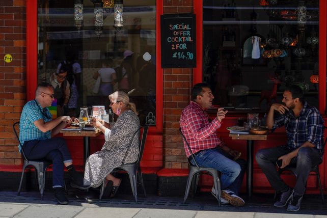 LONDRES. Clientes sentados en la vereda en un bar del Soho londinense. En Gran Bretaña el 95% de los casos son variante Delta.