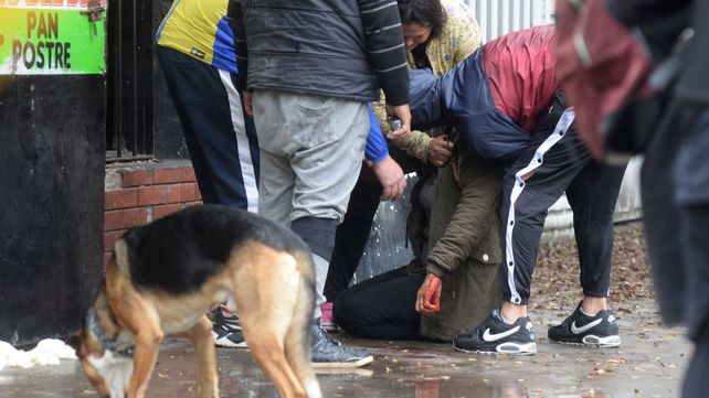 La madre de Elías Sergio Salinas, con su mano teñida con la sangre de su hijo, es contenida por familiares en la escena del crimen Pellegrini y Teniente Agnetta.