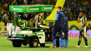 Agustín Sández es retirado en el carrito sanitario, acompañado por el médico Nicolás Rebagliati. Quiso seguir pero no pudo.