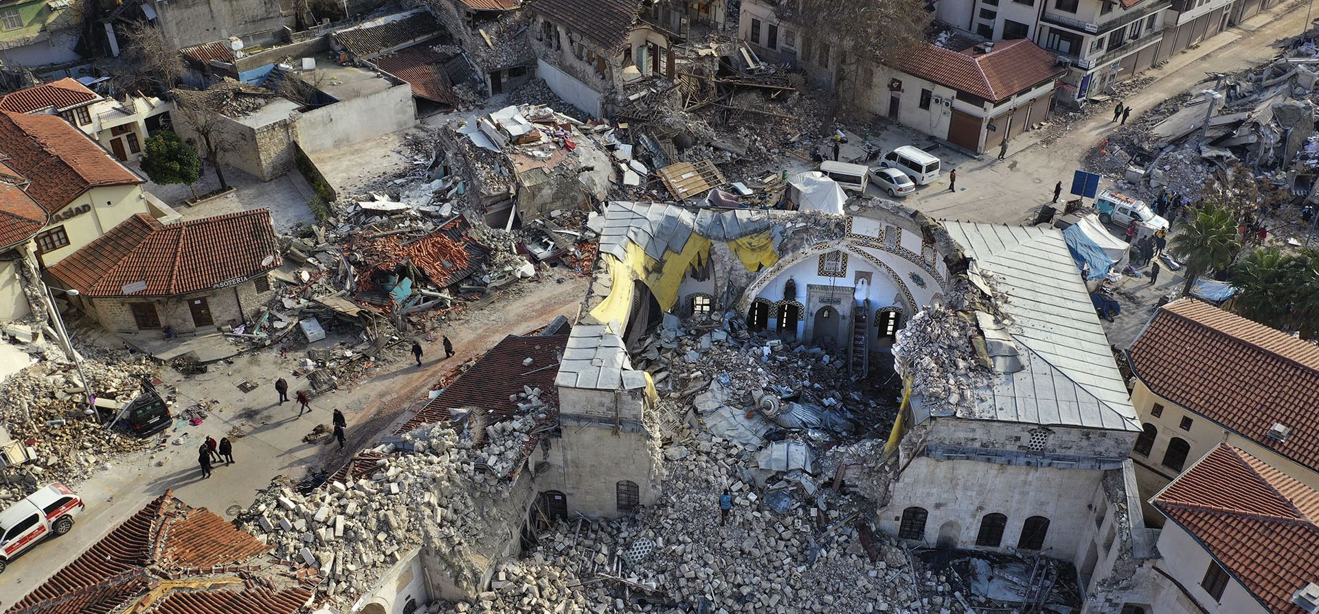 Ciudadanos turcos pasan junto a la histórica mezquita Habib Najjar que fue destruida durante el devastador terremoto, en la ciudad vieja de Antakya, Turquía, martes 21 de febrero de 2023. (Foto AP/Hussein Malla)