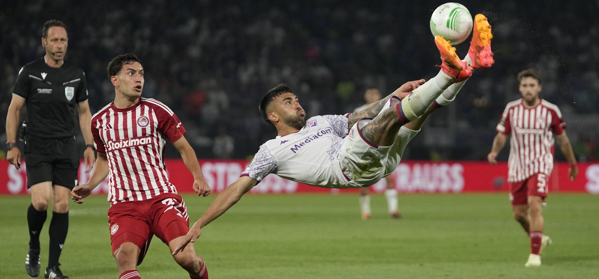 Nicolas González, de la Fiorentina, salta pateando el balón pasando a Santiago Hezze del Olympiacos durante el partido final de fútbol de la Conference League entre el Olympiacos FC y el ACF Fiorentina en el OPAP Arena de Atenas, Grecia, el jueves 30 de mayo de 2024. (Foto AP/Thanassis Stavrakis) Nicolas González, de la Fiorentina, salta pateando el balón pasando a Santiago Hezze del Olympiacos durante el partido final de fútbol de la Conference League entre el Olympiacos FC y el ACF Fiorentina en el OPAP Arena de Atenas, Grecia, el jueves 30 de mayo de 2024. (Foto AP/Thanassis Stavrakis)