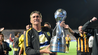 Edgardo Bauza alza en Mendoza el trofeo que ganó con Central en 2018.