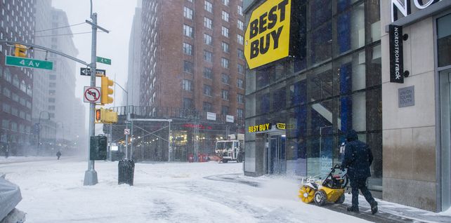 Un trabajador limpia la nieve de una acera cerca de Union Square durante la tormenta de nieve en Nueva York.