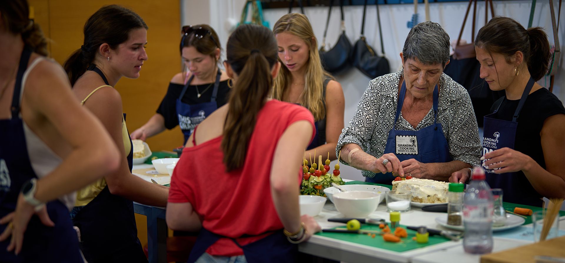 Nuria Isanda, de 75 años, enseña a turistas a preparar y presentar platos tradicionales españoles durante un taller de cocina en Grandmas Cooking, en Barcelona, España, el miércoles 14 de octubre de 2026. (Foto AP/Emilio Morenatti)